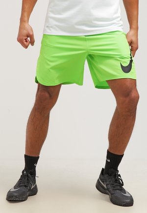 Shorts Nike de color verde neón con el logo negro de Swoosh, fabricados con material ligero, con un corte holgado y una cinturilla elástica.