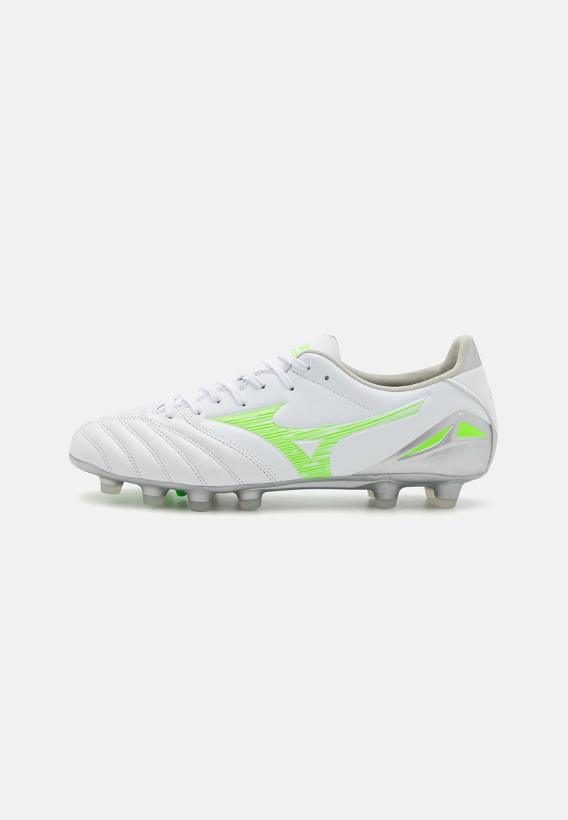 Scarpa da calcio bianca con accenti verdi, parte superiore strutturata e finish lucido. Presenta un sistema di allacciatura e suola multi-chiodata per la trazione.