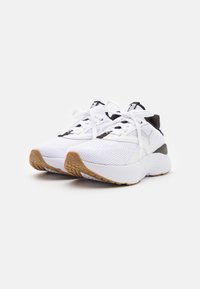 Witte sportchoenen met een bovenkant van mesh, zwarte accenten, platte veters en een gestructureerde gumrubberen zool. Beschikt over een gevoerde hiel voor extra ondersteuning.
