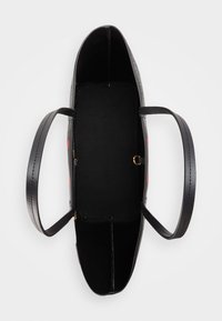 Černá kabelka s dvěma uchy, vnitřními přihrádkami a hladkým povrchem. Vzorovaný exteriér s červenými akcenty, který ukazuje strukturovaný tvar.