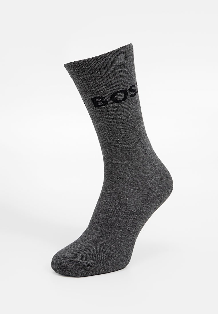 Graue Baumwollsocke mit gerippter Textur und verstärktem Zehenbereich, mit einem schwarzen Logo "BOSS" an der Seite. Standard Design in Crew-Länge.