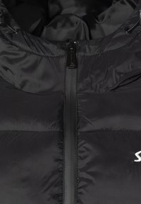 Giacca imbottita nera con esterno liscio, chiusura frontale con zip e collo alto. Presenta pannelli cuciti e un dettaglio del logo lucido.