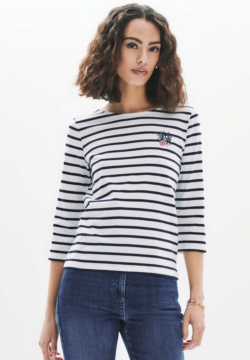 T-shirt med trekvart ärm i vit och marinblå randig design, med en blomsterbroderad patch på vänster bröst, tillverkad av mjukt och stretchigt material.