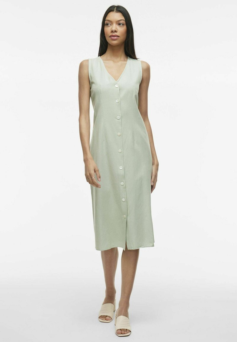 Robe midi sans manches vert clair avec un décolleté en V et une fermeture à boutons sur le devant, présentant une coupe droite et une texture subtile.