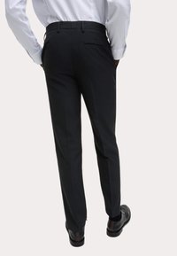 Czarne dopasowane spodnie wykonane z gładkiego materiału mają prosty krój, boczne kieszenie oraz jedną tylną kieszeń z klasycznym stanem.