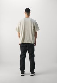 Under Armour Ulkohousut - black