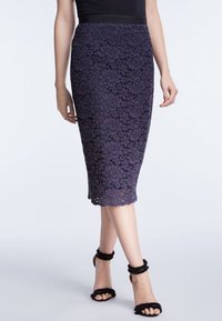 Krajková tužková sukně v tmavě fialové barvě s květinovým vzorem, ke kolenům, doplněná černými sandály na středním podpatku s volánkovými detaily.