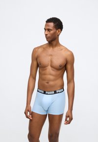 Pánske boxerky v svetlom modrom bavlnenom materiáli s čiernym elastickým pásom s logom Puma. Priliehavý strih s hladkou textúrou.