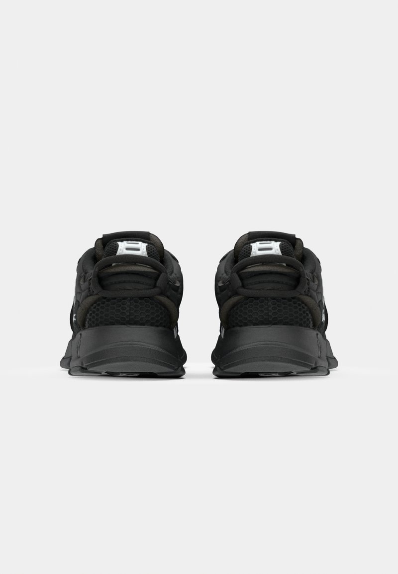 Czarne buty sportowe z chropowatą siateczkową cholewką, wyściółką w kołnierzu i wytrzymałą gumową podeszwą z akcentującymi paseczkami.