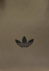 Barna, texturált szövet táska, kis fekete Adidas trefoil logóval és az alatta lévő három csíkkal.