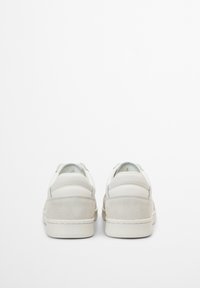 Sneaker bianche con una tomaia in pelle liscia, dettagli in suede e suola in gomma testurizzata. Presentano un design low-top e un colletto imbottito.