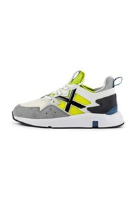 Sneaker mit einem weißen Mesh-Obermaterial, grauen Wildlederakzenten, schwarzem Logo, neon-gelben Einsätzen und einer weißen Sohle mit einem blauen Akzent an der Ferse.