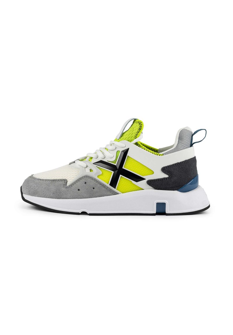 Sneaker mit einem weißen Mesh-Obermaterial, grauen Wildlederakzenten, schwarzem Logo, neon-gelben Einsätzen und einer weißen Sohle mit einem blauen Akzent an der Ferse.