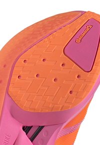 Lähivaade roosade ja oranžide jooksujalatsite tallast, millel on tekstureeritud haardepind, ventilatsiooniavad ja Continentali logo tallal.