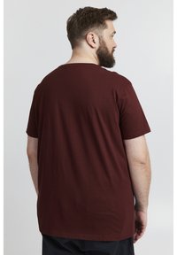 Bordeaux bomulds t-shirt med rund halsudskæring, korte ærmer og en afslappet pasform, der har en glat tekstur og ingen synlige mønstre.