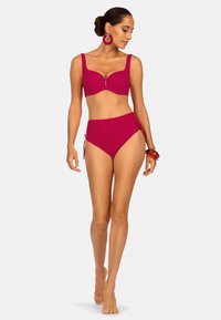 Magenta strój kąpielowy składający się z usztywnionego, wyściełanego biustonosza z szerokimi ramiączkami oraz majtek o wysokim stanie z wiązaniami po bokach. Gładka faktura.