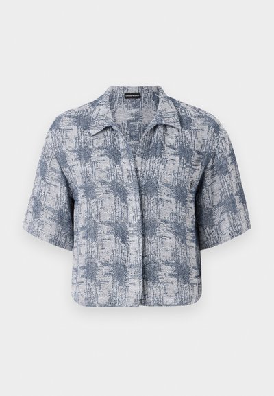 Majica s kratkimi rokavi iz lahkega in temno modrega teksturiranega blaga, ki ima ovratnik in geometrijski vzorec po celotni površini.