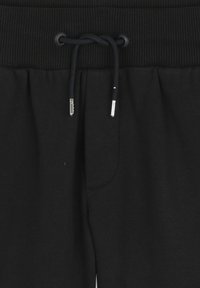 Zwarte sweatpants met een geribbelde tailleband, aantrekkoord met metalen accenten en zijzakken. Gladde stoftextuur met een comfortabele pasvorm.