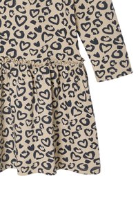 Beiges Kleid mit langen Ärmel, das über einen schwarzen Herz-Leopardenprint, einen elastischen Bund mit Rüschendetails und einen ausgestellten Rock verfügt. Weicher Stoff mit angenehmer Textur.