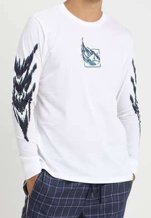 Langärmliges weißes Baumwollhemd mit dunkelblauen grafischen Designs auf den Ärmeln und einem kleinen zentralen Grafikdruck. Glatte Textur.