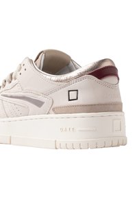Sneaker bianco con dettagli in argento e bordeaux, materiali in pelle e suede, suola intermedia testurizzata e dettagli del brand sul tallone.
