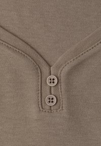 Top in maglia beige con scollatura a V, due bottoni tondi a quattro fori e bordi a coste stretti. Texture morbida e finitura senza cuciture.