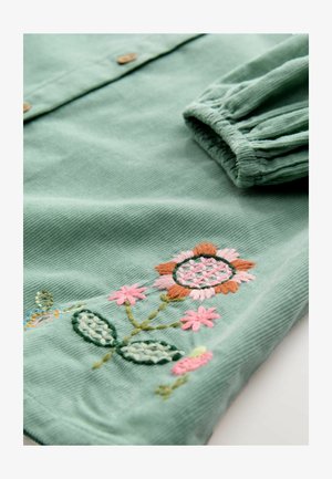 Roheline kootud särk roosa ja oranži lillekirjaga, millel on nupud ja volditud mansetid. Tekstuuriga kude koos keerukate detailidega.