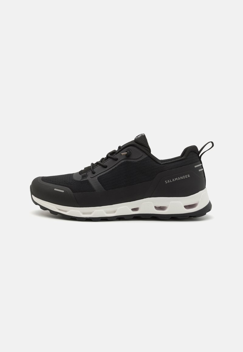 Black athletic shoe with a mesh upper and rubber sole. Features a white midsole and branding on the heel. Laces and a pull tab included.