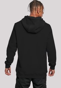 Black hooded sweatshirt with a smooth texture, ribbed cuffs, and hem. Features a spacious hood and a relaxed fit, showcasing a simple design.