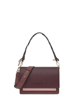 Bolso de hombro de cuero burdeos con el logo "TOUS" en relieve, banda de acento rosa, correa ajustable y herrajes dorados.
