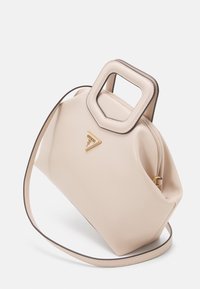 Beige faux læder taske med et kvadratisk håndtag, guld logo accent og en aftagelig skulderrem. Har en glat tekstur og en struktureret form.
