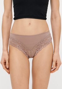 Culotte en dentelle marron avec une base en tissu lisse. Présente une bordure en dentelle florale le long de la ceinture et des ouvertures des jambes, créant un design délicat.