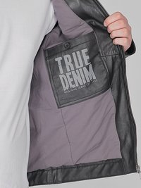 Svart läderjacka med grå foder, som har en "TRUE DENIM" etikett på en ficka, designad med en slät textur och dragkedjestängning.
