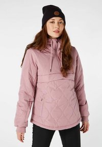 Lichtroze gewatteerde jas met een hoge kraag, trekkoordkap, en geribde mouwen. Draag het over een zwarte top, gecombineerd met een zwarte beanie.
