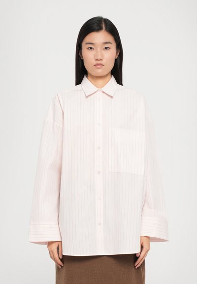 Camisa a rayas rosa claro con cuello abotonado, mangas largas y un bolsillo de parche. Presenta sutiles rayas finas y un corte relajado.