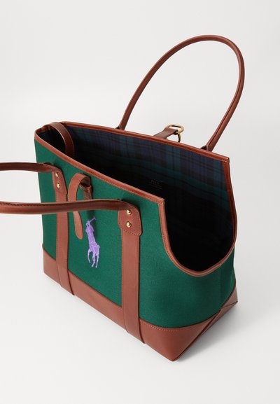 Tote bag din pânză verde cu accente din piele maro. Prezintă un logo brodat cu un jucător de polo purpuriu și o căptușeală interioară în carouri.