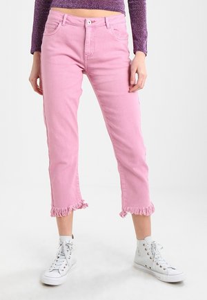 Jeans cortos rosas con dobladillo deshilachado, hechos de mezclilla, que presentan un diseño estándar de cinco bolsillos y una cremallera de botón. Combinados con zapatillas blancas.
