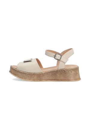 Beige, leather sandals with open toe, ankle strap, and silver hardware accent. Thick, textured wooden platform sole.
