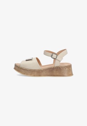 Beige, leather sandals with open toe, ankle strap, and silver hardware accent. Thick, textured wooden platform sole.