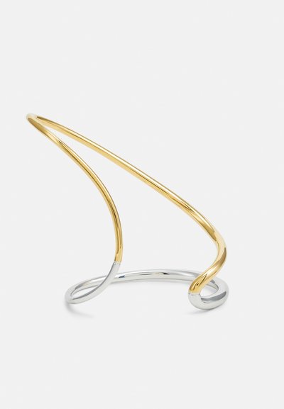 Zlato in srebro kovinski zapestnica, ki vsebuje ukrivljene, prepletene oblike z gladkim, sijočim zaključkom in brez dodatnih dekorativnih elementov.