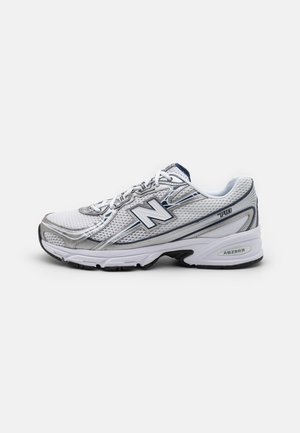 Biało-szary but do biegania New Balance 740 z siateczkową cholewką, sznurowadłami i wyściełaną podeszwą widziany z boku.
