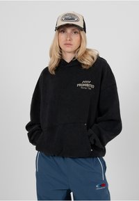 Sweat à capuche noir avec un logo indiquant "PROHIBITED Racing Club", poche avant, assorti à un pantalon bleu avec une bande latérale et un logo.