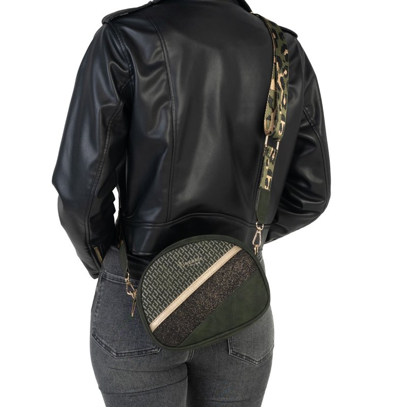 Femme portant une veste en cuir noire et un jean gris, elle porte un sac bandoulière arrondi avec des parties vertes, pailletées et à motifs.