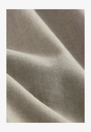Svijetlosiva tkanina s glatkom, tkanom teksturom i dijagonalnim rebrastim uzorkom. Mekan izgled, prikladna za razne tekstilne primjene.