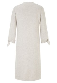 Robe beige à manches longues avec une coupe droite, ornée de nœuds noués au bout des manches, vue de dos.