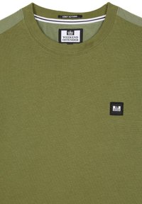 Oliven grøn t-shirt lavet af bomuld, med rund halsudskæring, korte ærmer og et sort label på brystet med hvid tekst.