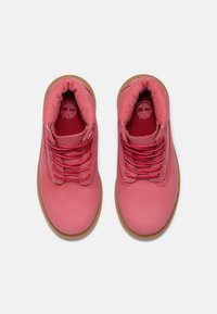 Stivaletti alla caviglia in pelle rosa con punta rotonda e suola in gomma testurizzata. Presentano lacci rossi e un interno foderato; design minimale.
