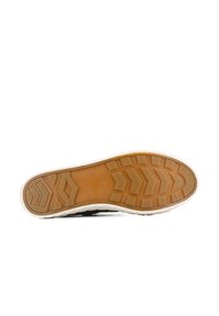 Semelle de sneaker en caoutchouc avec un motif de tread texturé en marron clair, une semelle intermédiaire blanche et un bord supérieur noir.