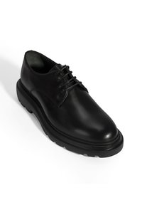 Schwarze Leder Derby-Schuhe mit runder Zehenpartie, sechs Ösen Schnürdesign und dicker, strukturiertem Gummisohle mit leicht erhöhtem Profil.