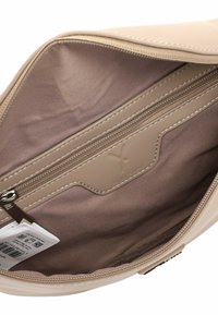 Beige synthetische tas binnenkant met een gladde textuur, voorzien van een ritssluitingvak en logodetail. Voering is een lichtbeige stof.